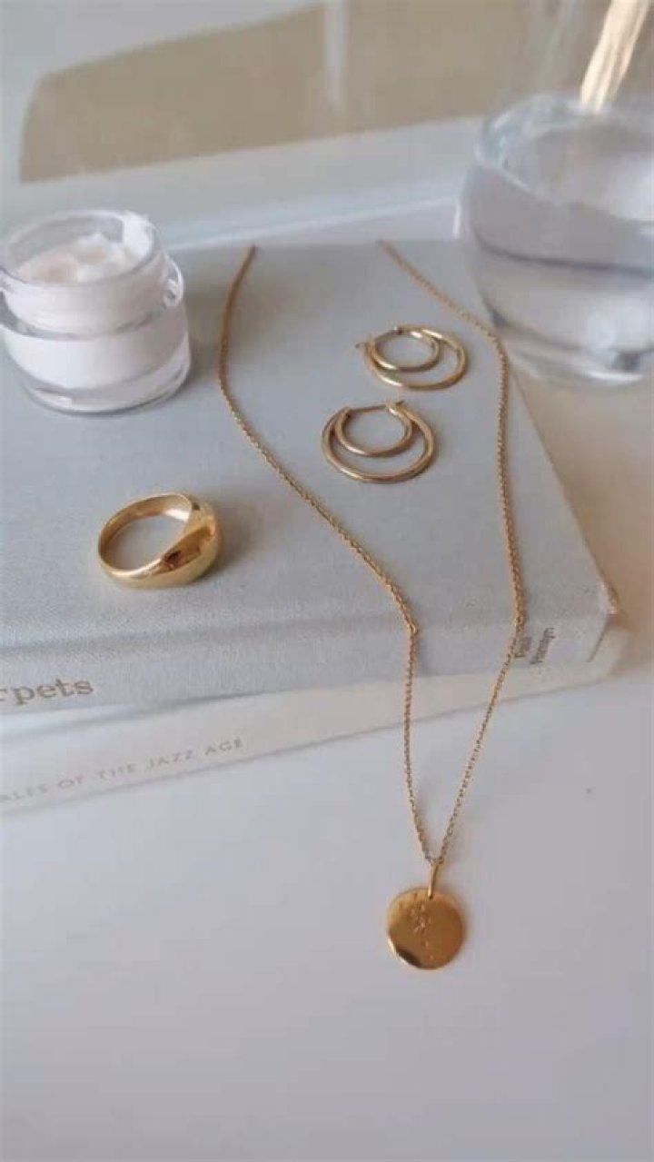Minimalist gold jewelry and straw hat accessory for beach ceremony